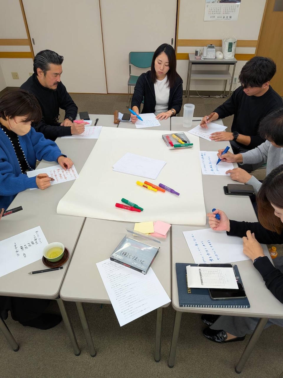 One Day Meeting のワークシートに向き合いながら、社員が考えを書き出している場面