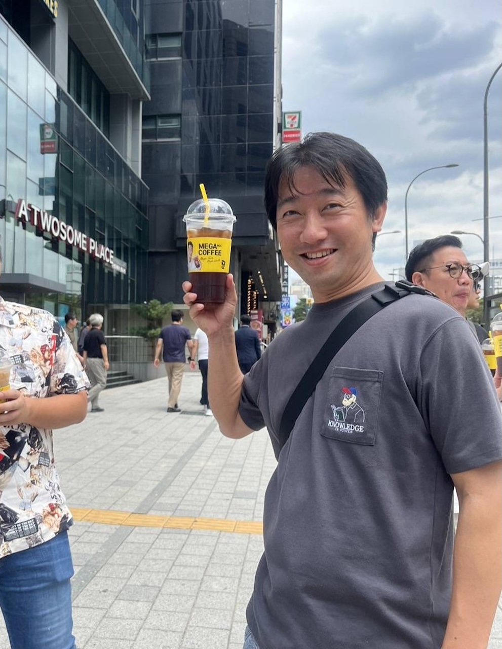 室内で打ち合わせをしながら穏やかに微笑む男性の横顔。落ち着いた雰囲気で相手と対話している様子