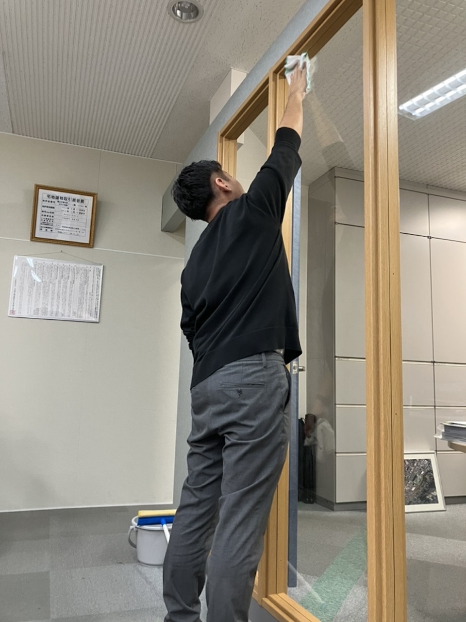 年末の大掃除で窓を拭き、一年の汚れを落とすスタッフの様子