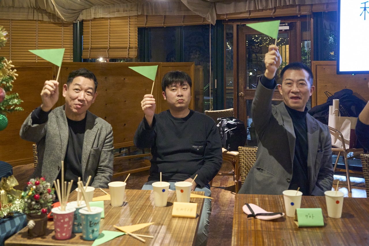 株式会社くりえいと・エスコム合同忘年会で行われた格付けチェック企画に挑戦する参加者の様子