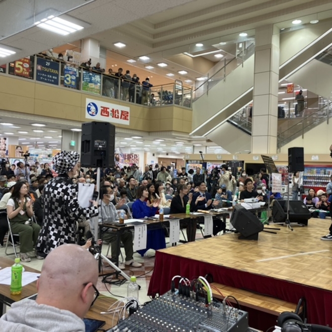 商業施設サンリブくりえいと宗像の特設ステージで行われるイベントを多くの観客が見守っている様子