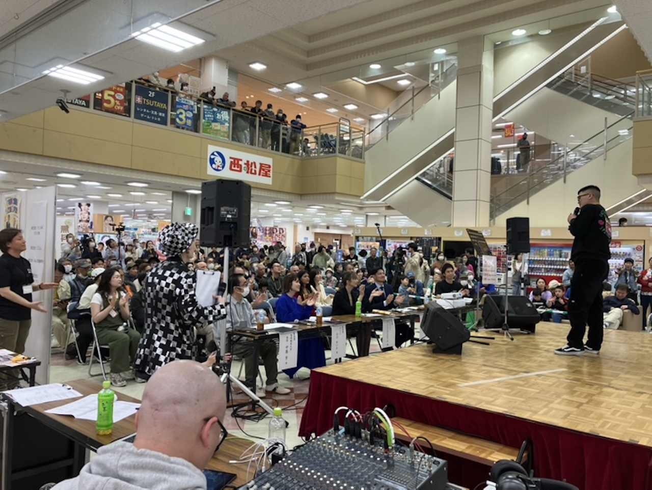 商業施設サンリブくりえいと宗像の特設ステージで行われるイベントを多くの観客が見守っている様子