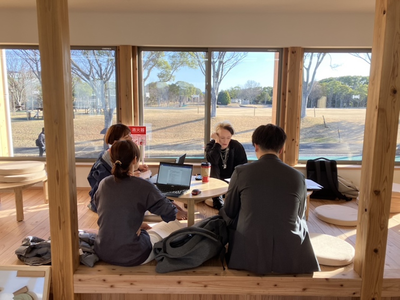 宗像ユリックス芝生広場が見える全天候型こども広場Mu_Moで円卓を囲み話し合うメンバーの様子