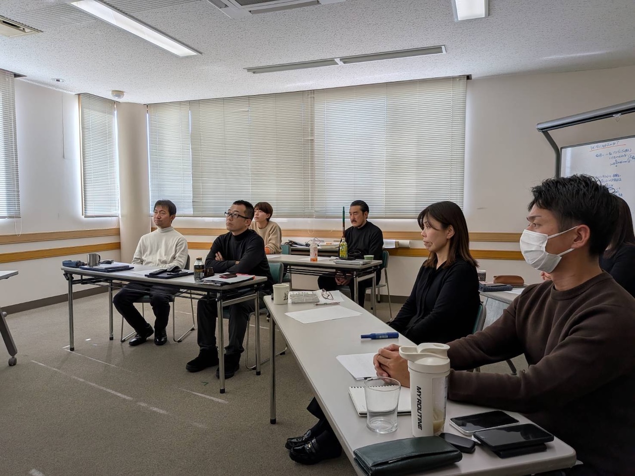 会議室でOne Day Meetingに集中して参加するメンバーの様子。ノートPCやメモを広げ、議論に臨む(宗像・くりえいと)