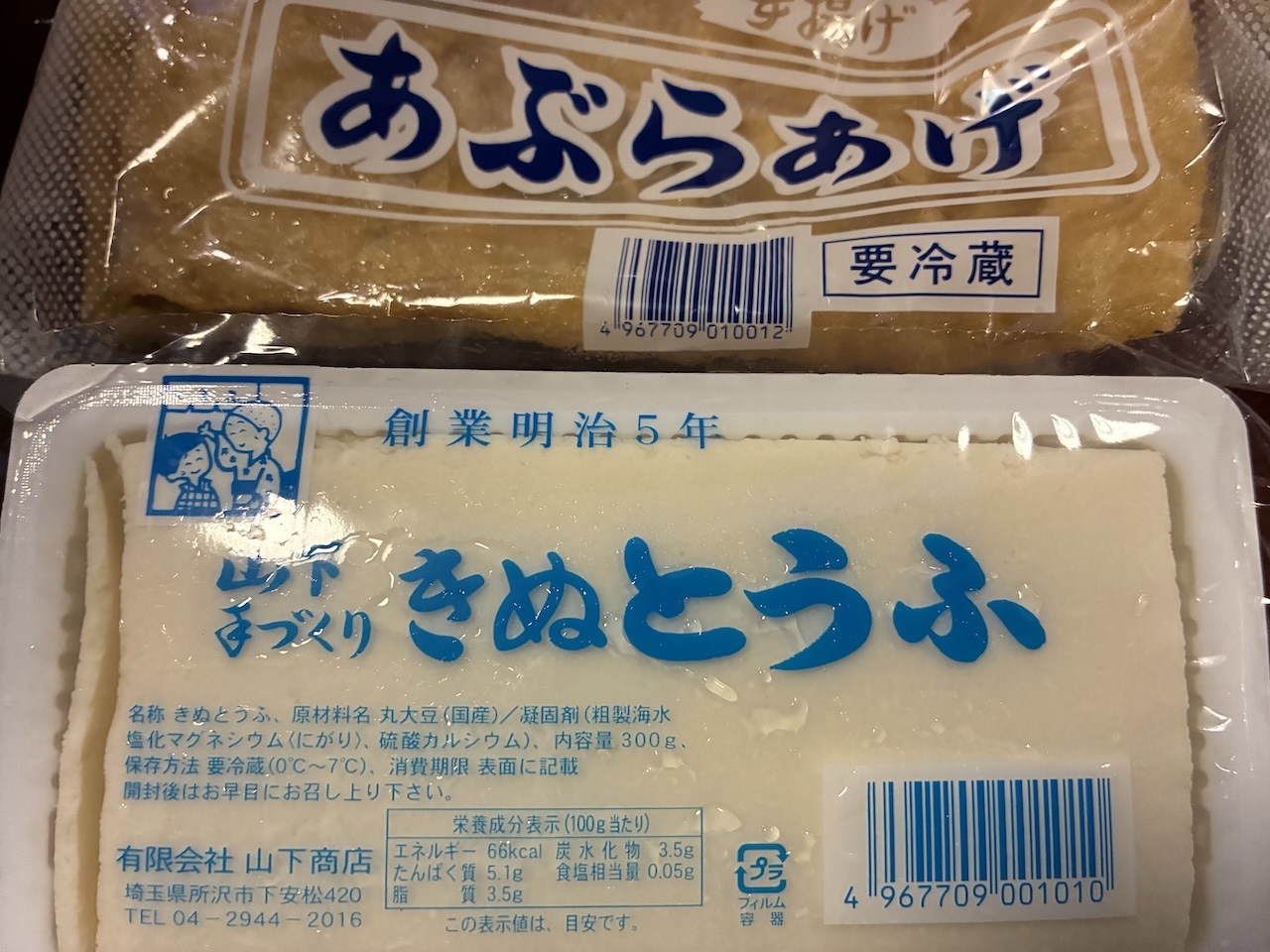 山下商店で購入した豆腐と油揚げのパッケージ。商品名やラベルが写っている