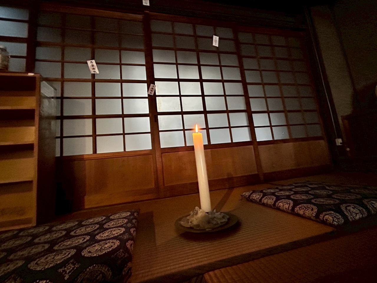 ろうそくの灯りが揺れる畳の語り席と障子が印象的な怪談イベントのステージ風景