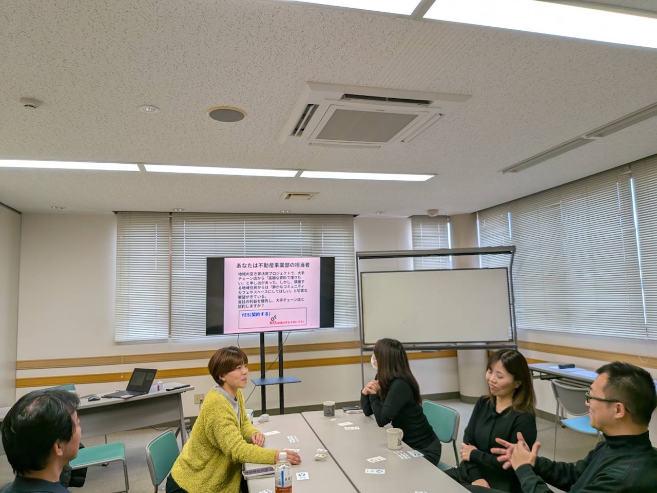 参加者がクロスロード形式のワークで意見を出し合っている会議室の様子