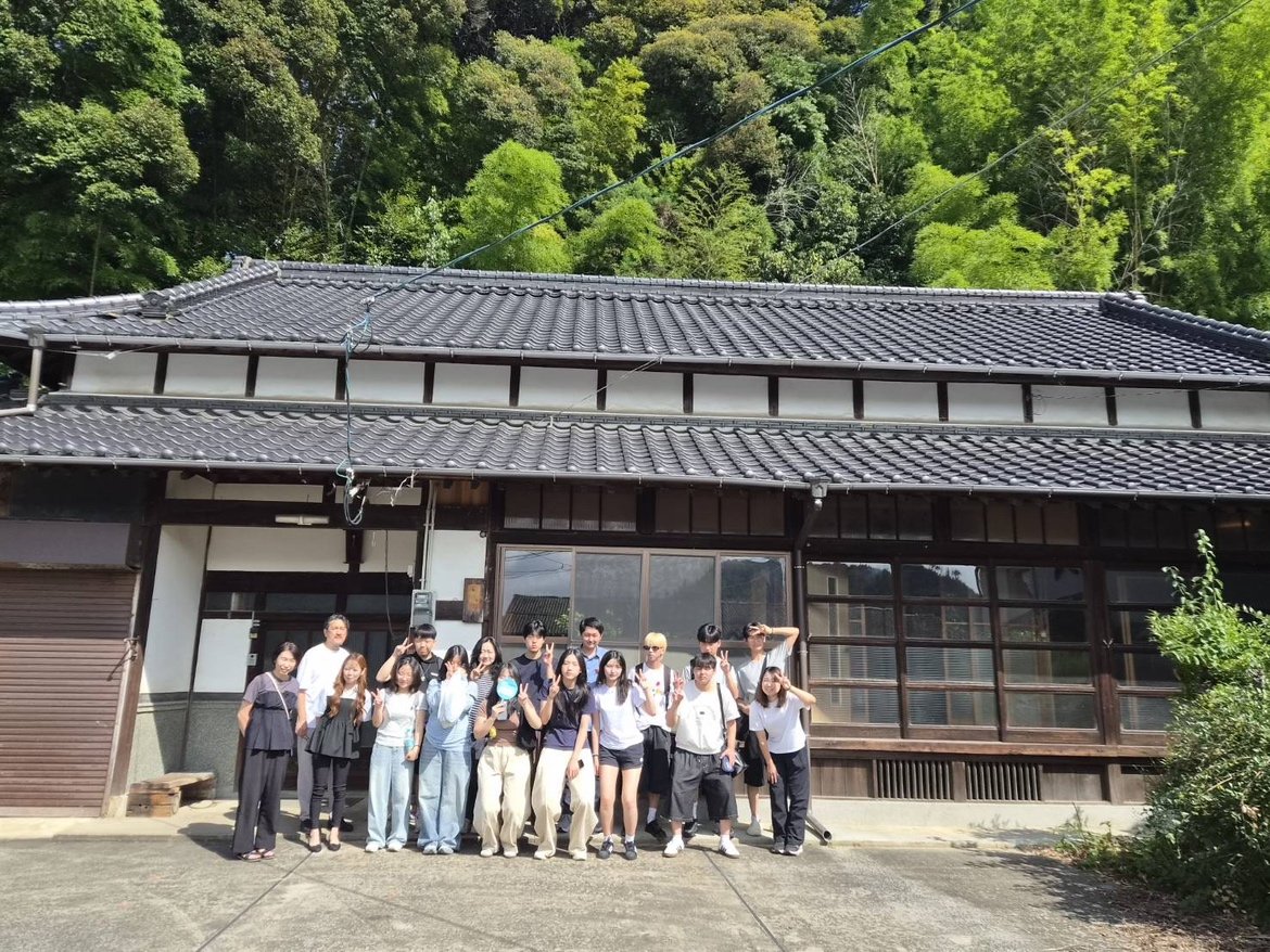 築150年の古民家母屋の前で記念撮影する韓国・金海市ズノウ日本語学校の先生と生徒13名