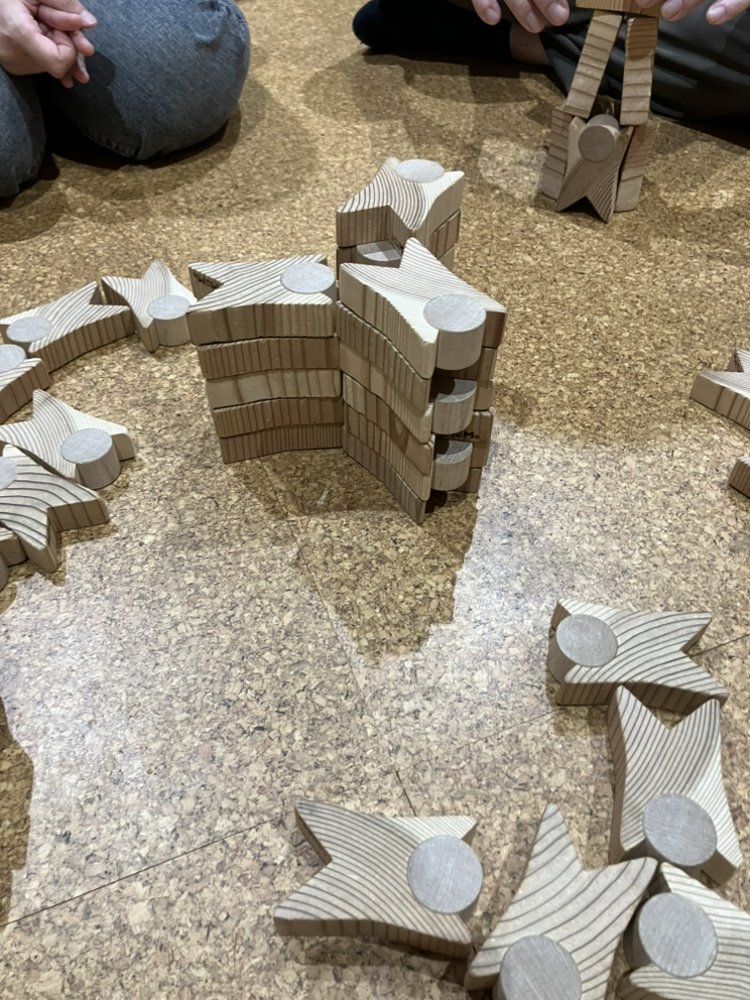 コルク床の上に横に広げて並べられたつみぼぼの積み木作品