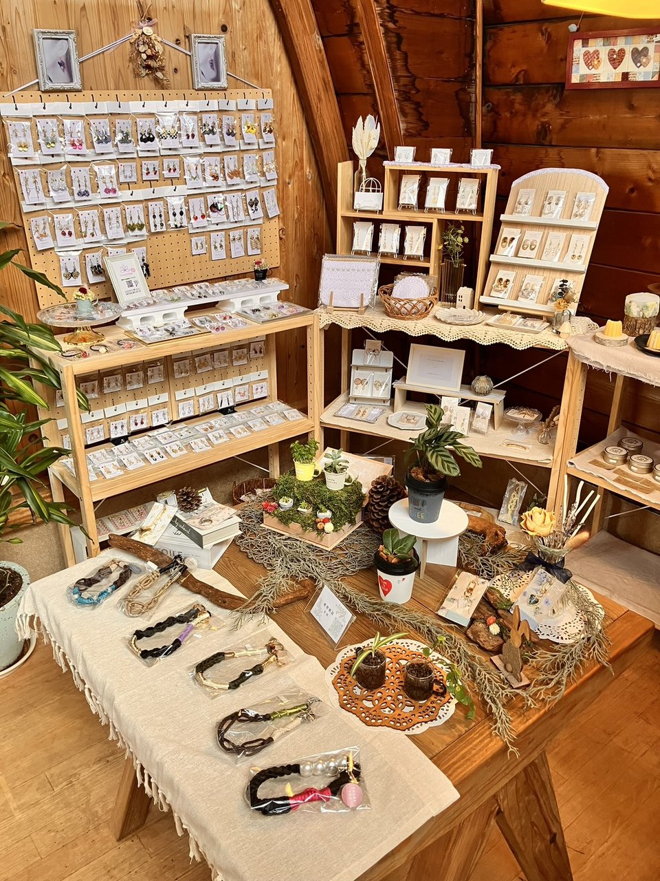 木の温もりある店内に並ぶハンドメイド作家によるピアスやブレスレットなどのアクセサリー