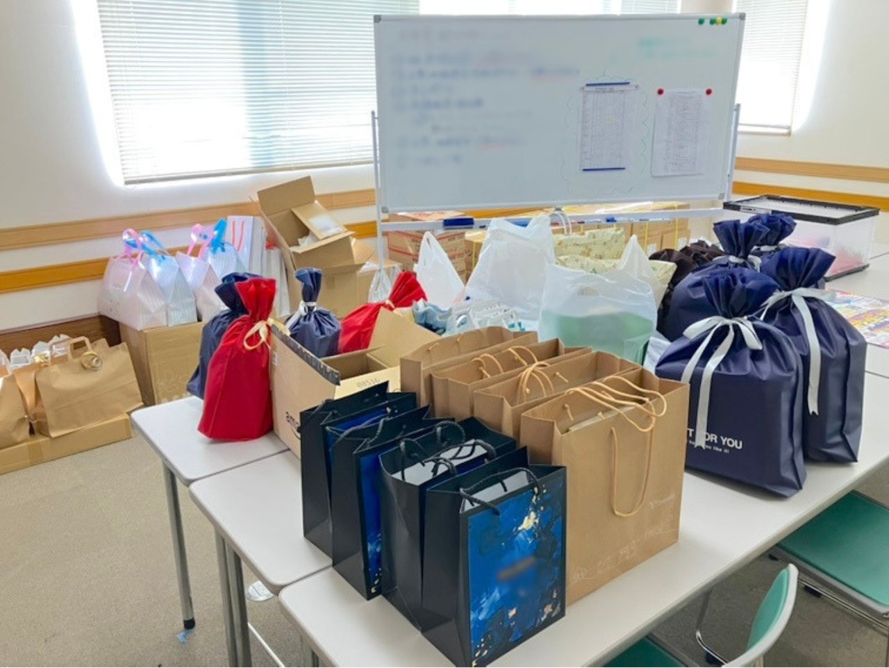 会議室のテーブルに並べられた抽選会・BINGO大会用の景品袋や紙袋